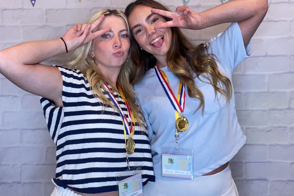 Two friends flashing peace signs and laughing at an InstaGlee photo booth